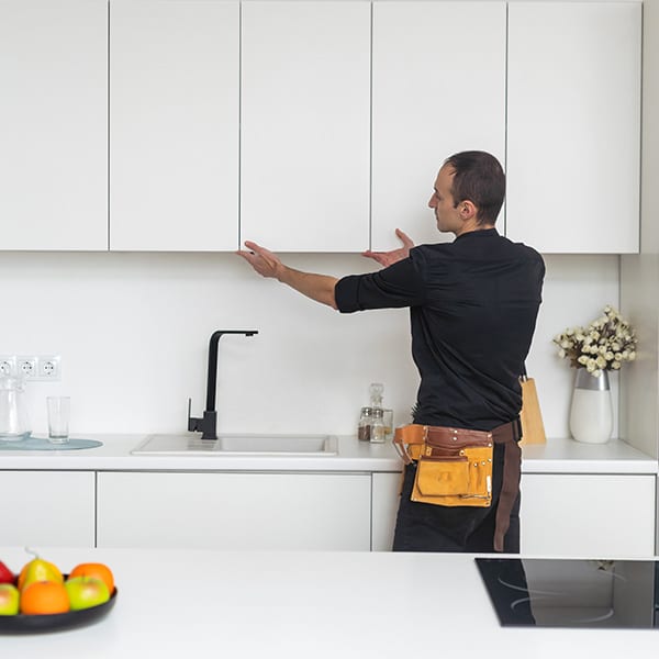 young handyman in overall installing drawer